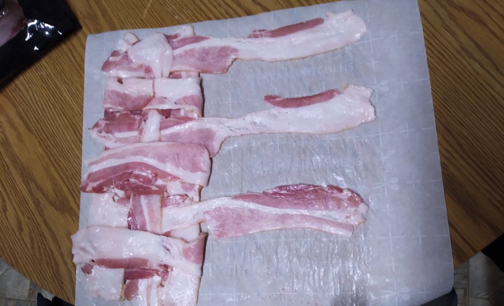 Using Chef PK's technique, weave the bacon slices on a cutting board.