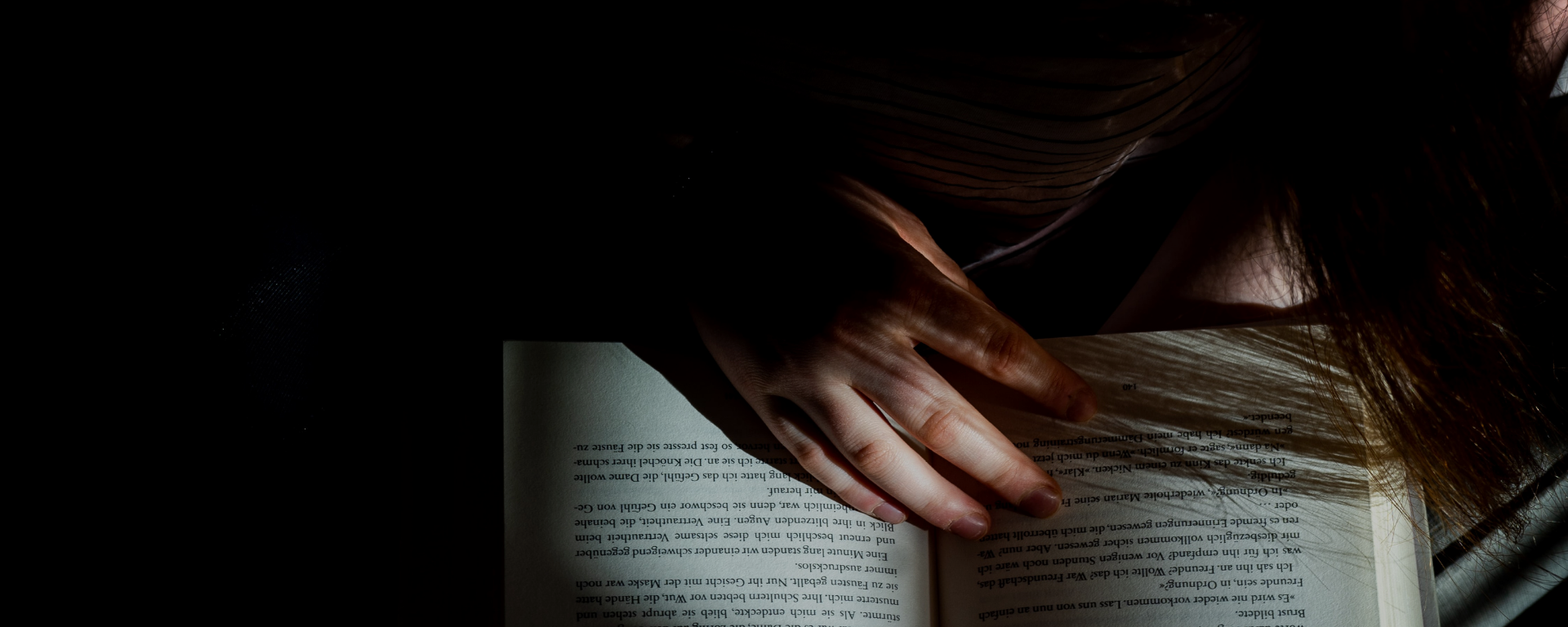 a woman reads a book in the dark